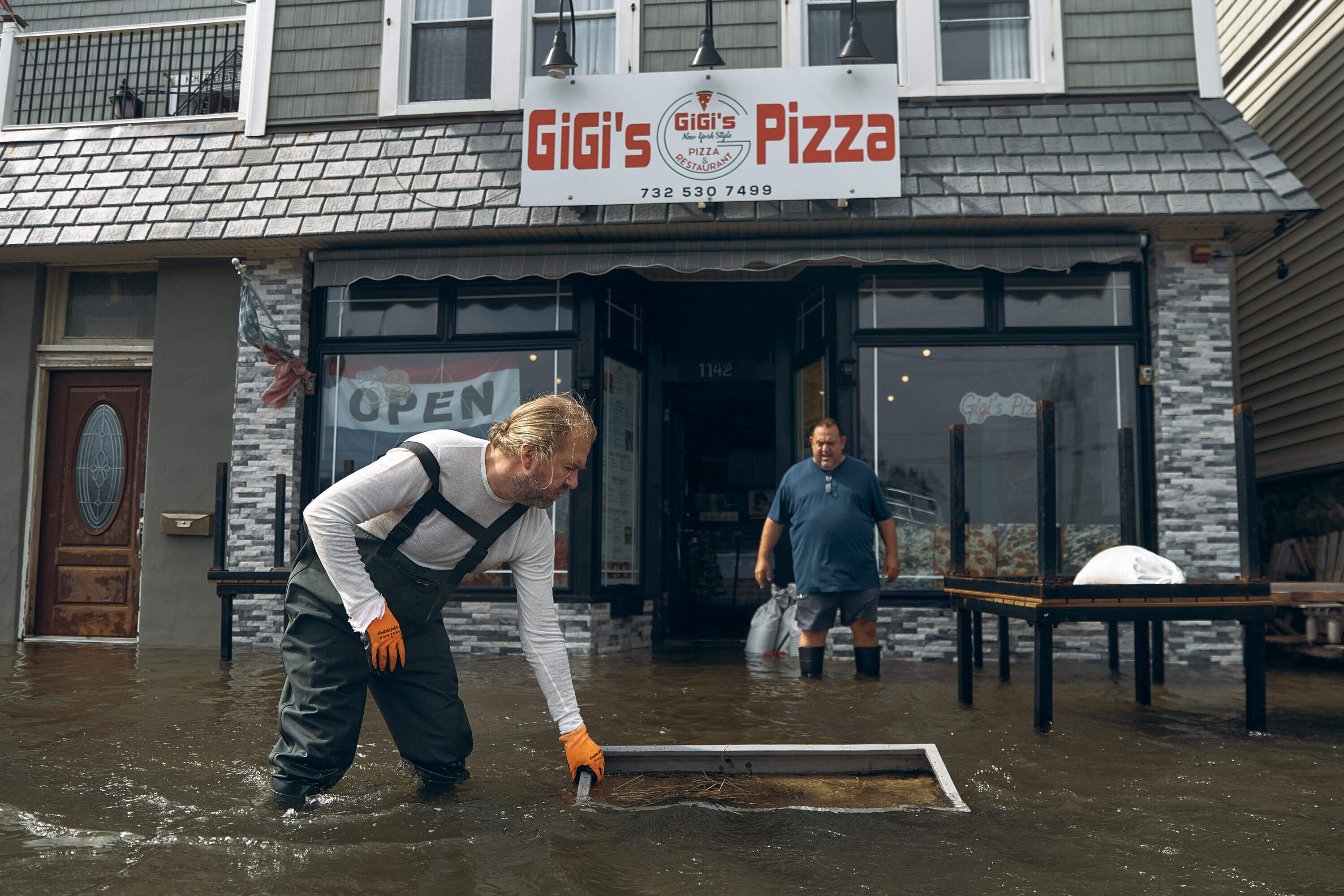 People work to clean a flooded pizza restaurant during the nor'easter in Sea Bright, N.J. (Andres Kudacki/AP)