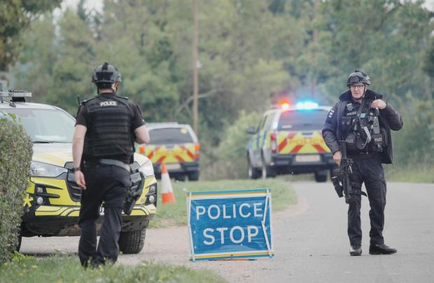 Police stand at a road block on the road to RAF Fairford after an incident, in Whelford, England, Sunday, Sept. 27, 2026 .(Ben Birchall/PA via AP)