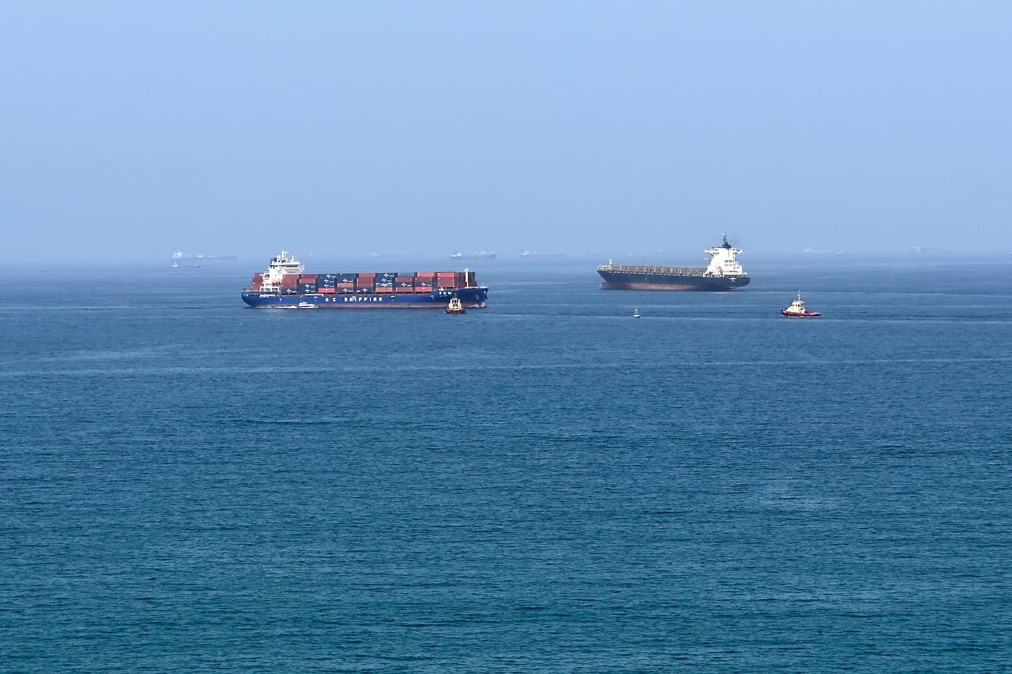 A cargo ship is pictured off coast of the Khor Fakkan Container Terminal, the only natural deep-sea port in the region and one of the major container ports in Sharjah Emirate, along the Gulf of Oman on June 28, 2026. Iran's top diplomat warned on June 28 that any attempt by shipping to bypass its preferred route through the Strait of Hormuz would "increase tensions" in the Middle East, as US and Iranian forces again traded attacks across the vital seaway.