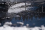 FILE — Reflected in a pool of melting ice, dirt and grass show through the low snowpack at Mt. Hood Meadows on the resort’s second-to-last weekend in Mt. Hood, Ore., on April 4, 2026.