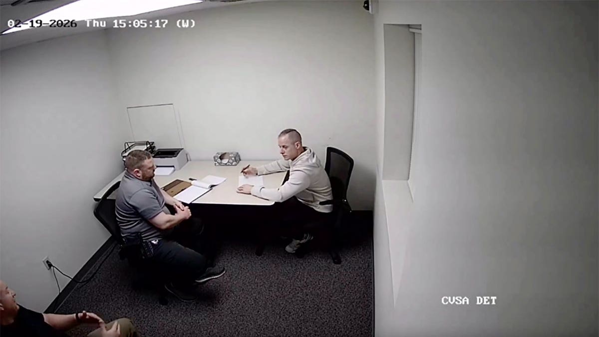 Caleb Flynn sits across a table from an investigator during a recorded police interview shown to jurors in his Ohio murder trial.