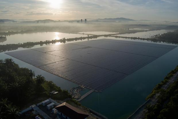 The sun rises over floating solar panels.