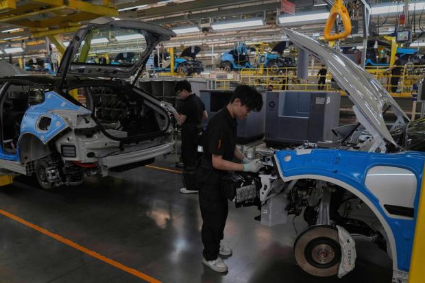 Workers assemble the Zeekr 001 EV models.