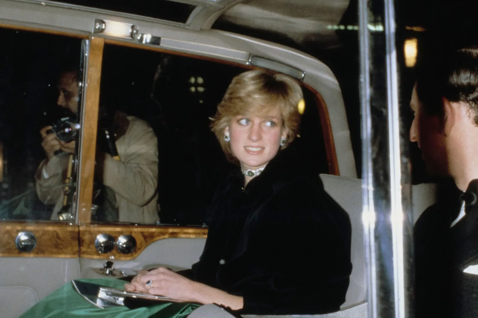 Princess Diana talks to then-Prince Charles as photographers crowd their car before a gala concert in Swansea, Wales, November 1981.