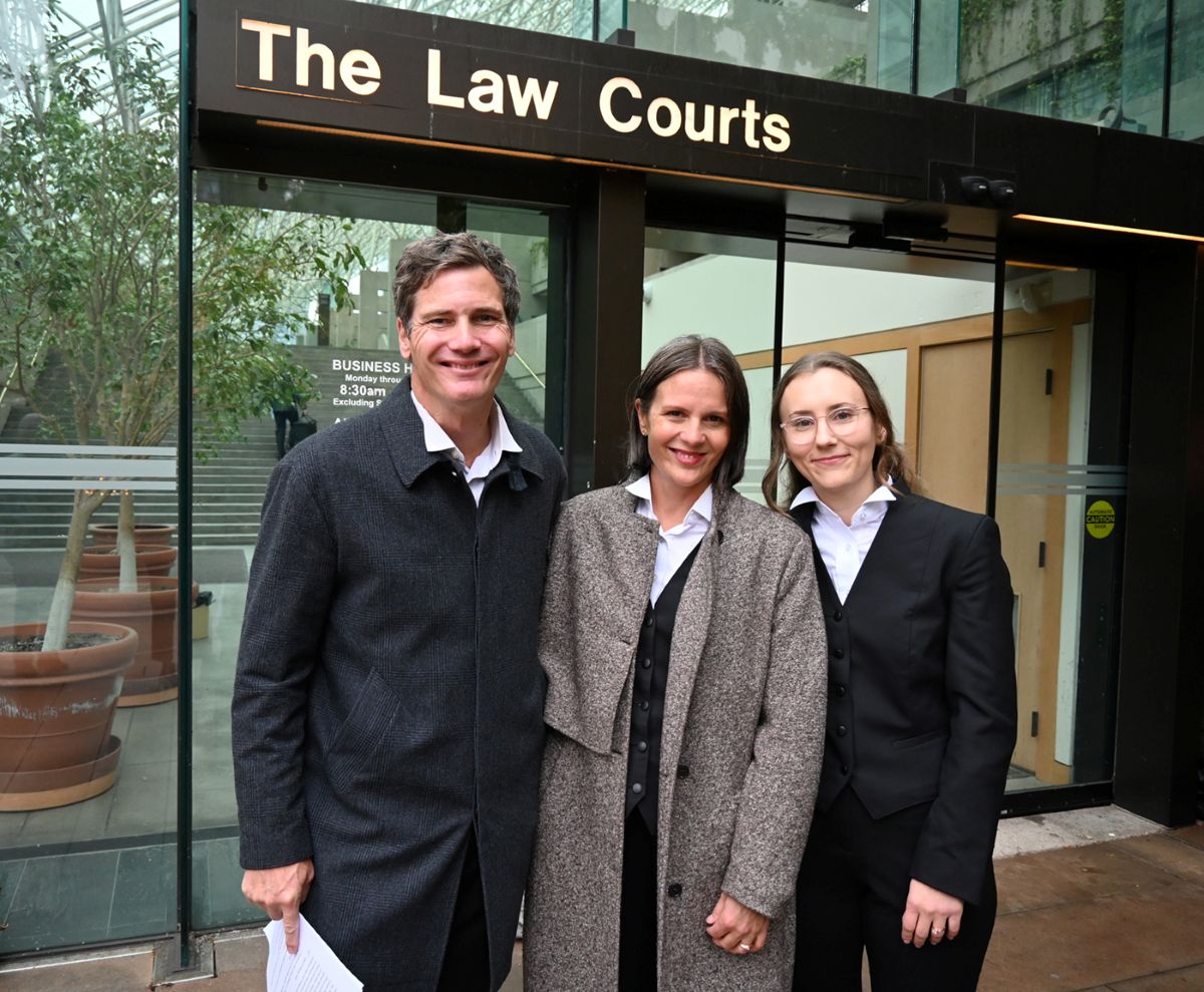 DULF’s three lawyers smile and pose for a photo in front of the Vancouver courthouse.