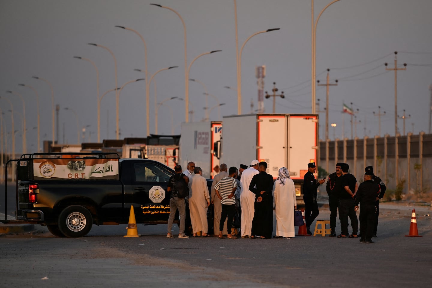 Stranded Iranians and Iraqis waited at the Iraq-Iran border following the Iraqi government's decision to close the Shalamsheh border crossing in the southern Basra province on Saturday.