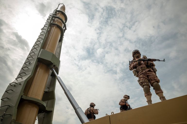 Islamic Revolutionary Guard Corps (IRGC) military personnel stand guard next to an Iranian Kheibar Shekan Ballistic missile in downtown Tehran during a rally commemorating International Quds Day, also known as Jerusalem Day, on April 29, 2022