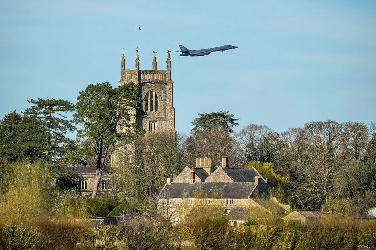 A USAF Rockwell B-1 Lancer bomber takes off on a sortie from RAF Fairford over the Cotswold village of Kempsford and the village church of St. Mary the Virgin on March 21, 2026 in Fairford, England.