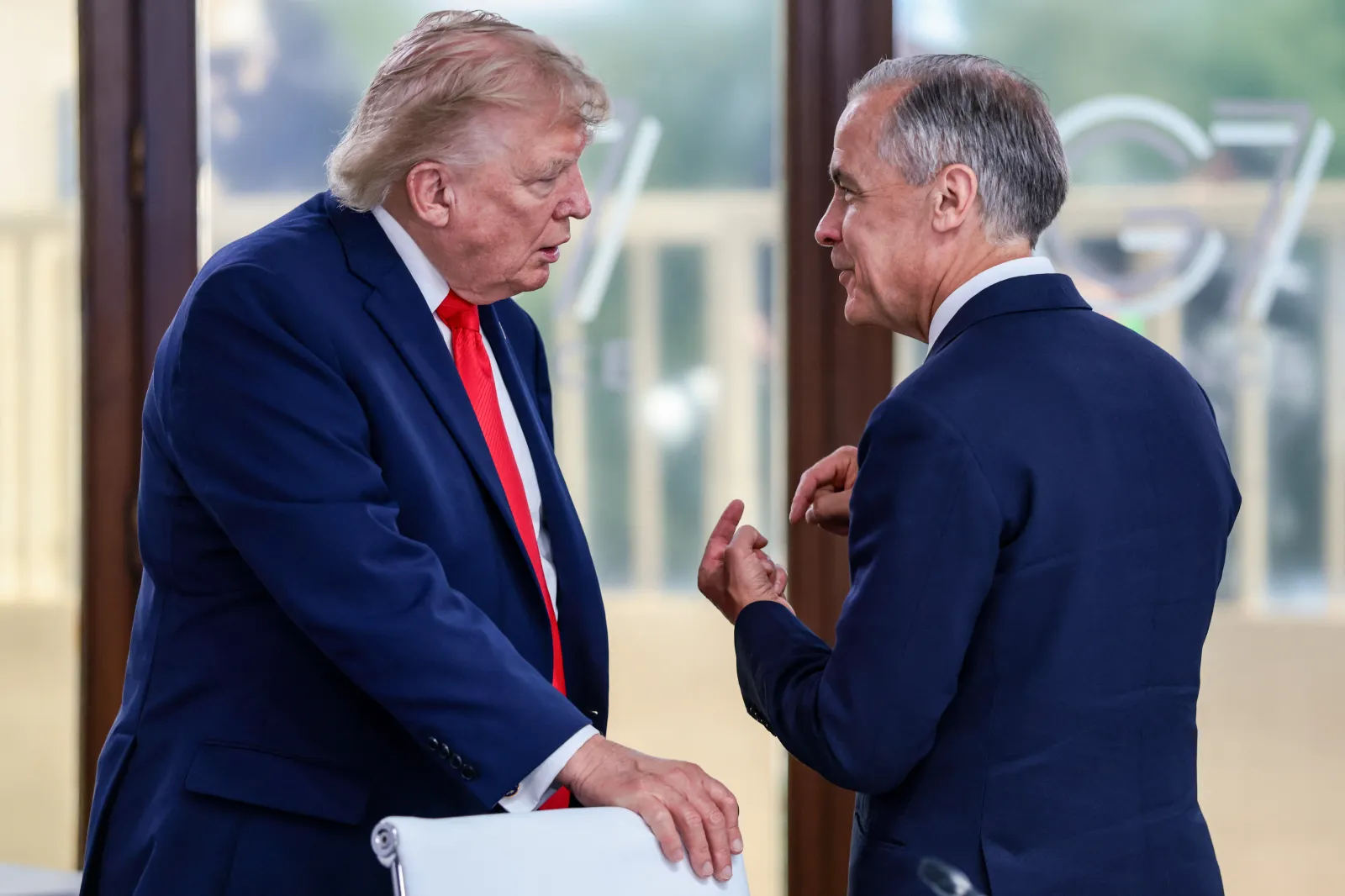 President Donald Trump speaks with Canada's Prime Minister Mark Carney during a work lunch as part of the G7 summit, in Evian, eastern France, on June 16. (Photo by Evelyn Hockstein / POOL / AFP via Getty Images)