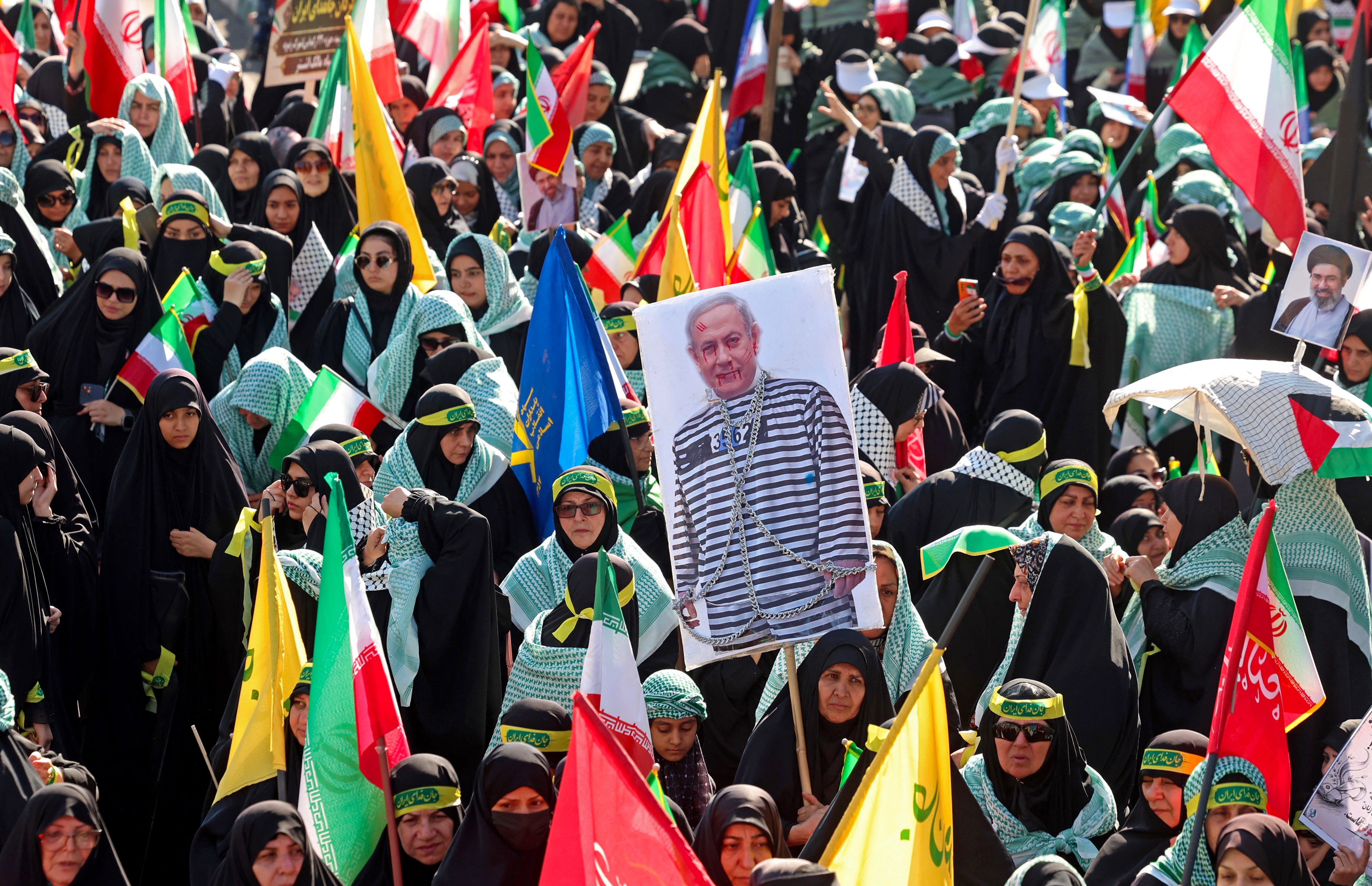 A woman holds a placard depicting Israeli Prime Minister Benjamin Netanyahu during the rally