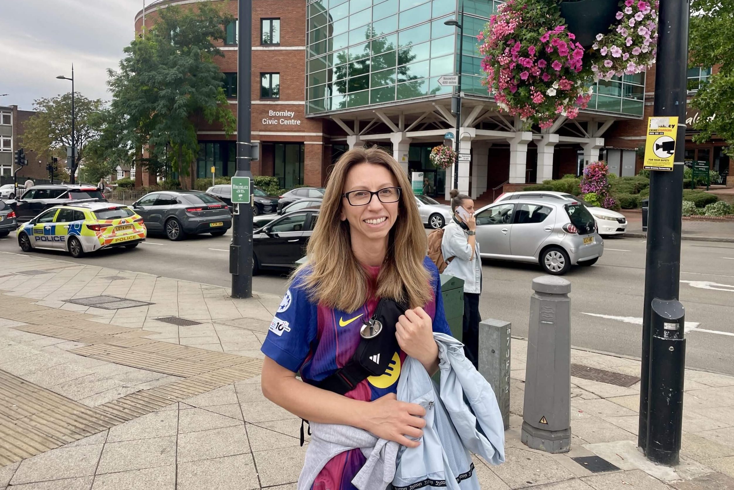 A fan wearing a Barcelona shirt poses on the street