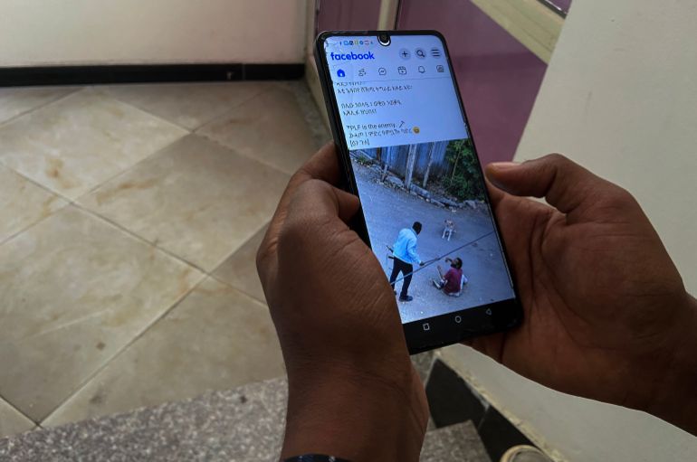 Shewit, 24, a Tigrayan who fled forced military conscription by Tigray People's Liberation Front (TPLF), reads a news on his phone in his apartment after interview with Aljazeera, in Addis Ababa, Ethiopia, September 22, 2026.