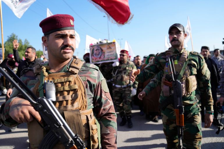 Members of an Iraqi Shiite militant group carry the coffin of an fighter with the Kataib Hezbollah militia, who was killed in a U.S. airstrike in Babil Province, during his funeral in Baghdad, Iraq, Tuesday, Dec. 26, 2023. (AP Photo/Hadi Mizban)