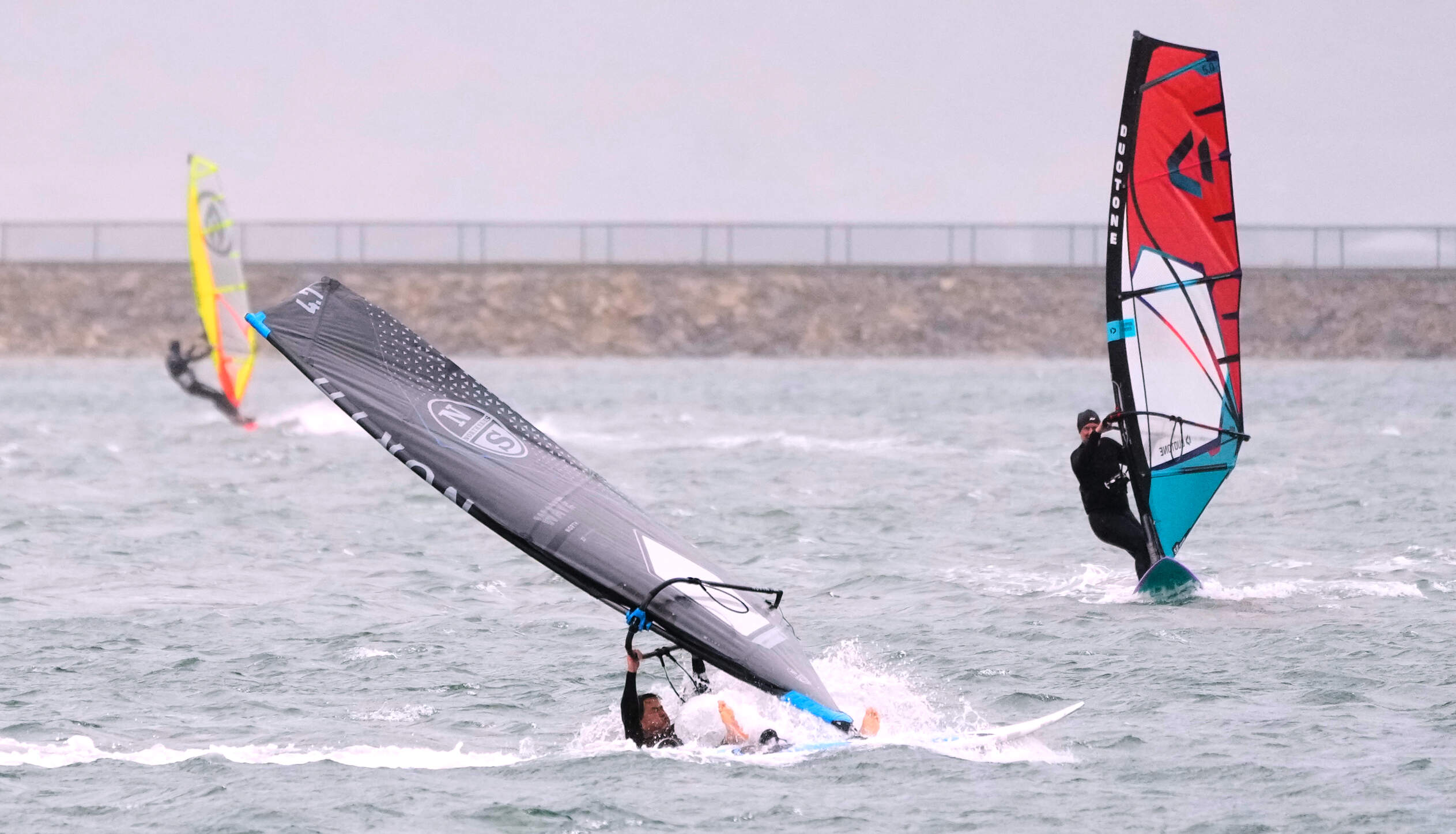 A windsurfer wipes out as others rip along the shore during a nor'easter storm at Pleasure Bay, Saturday, Sept. 26, 2026, in Boston. (Charles Krupa/AP)