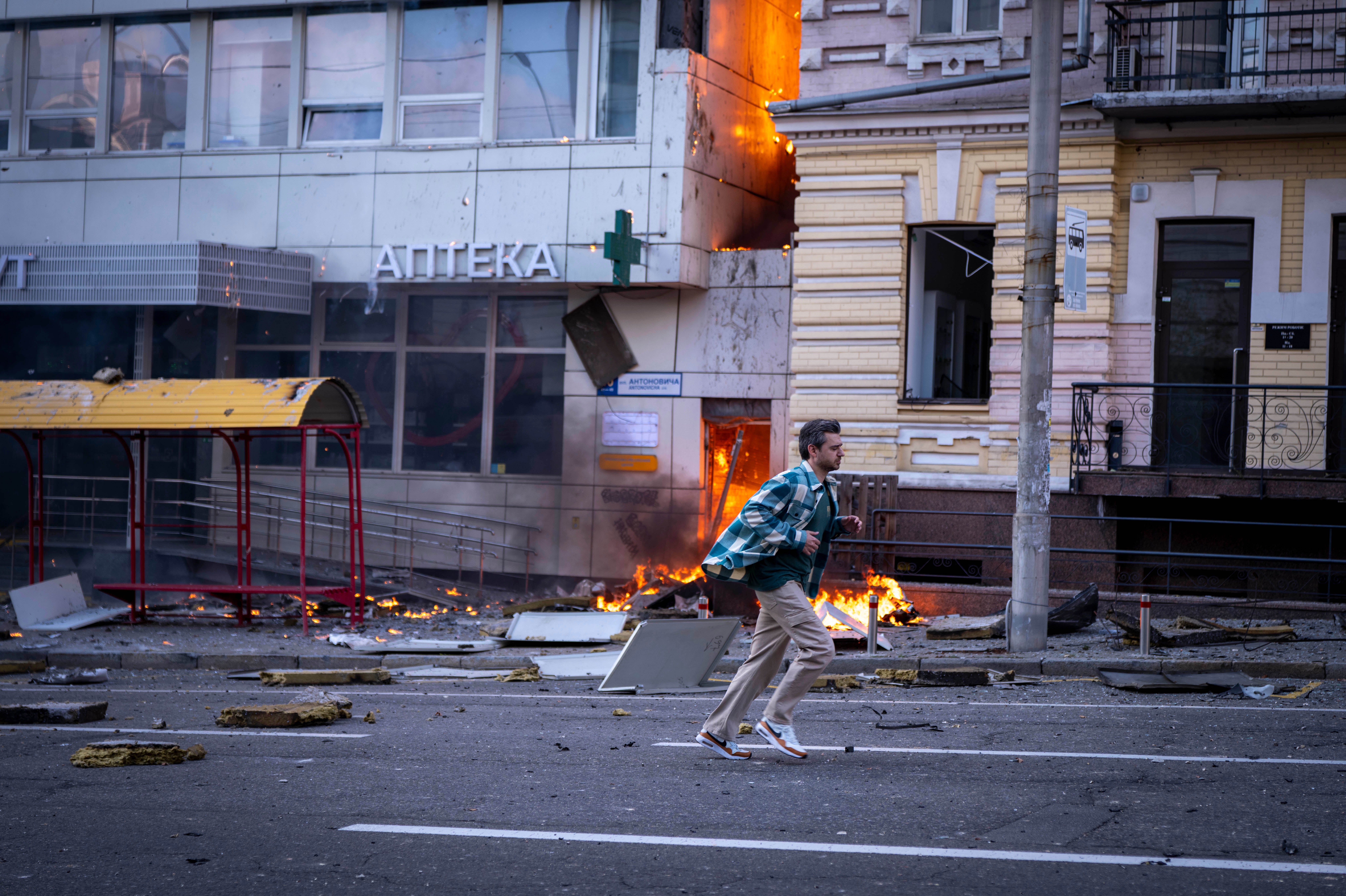 A man runs in front of a hospital damaged after a Russian drone strike in central Kyiv, Ukraine