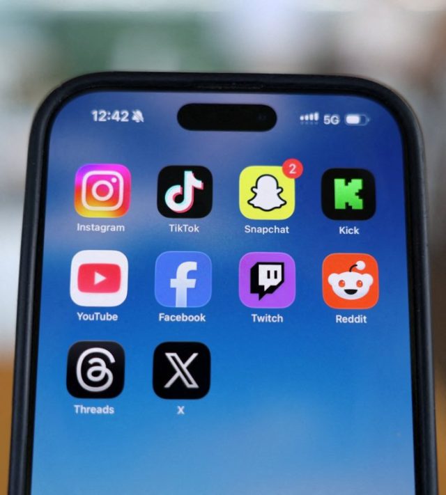 FILE PHOTO: Instagram, TikTok, Snapchat, Kick, YouTube, Facebook, Twitch, Reddit, Threads and X applications are displayed on a mobile phone ahead of new law banning social media for users under 16 in Australia, in this picture illustration taken on December 9, 2025. REUTERS/Hollie Adams/Illustration/File Photo