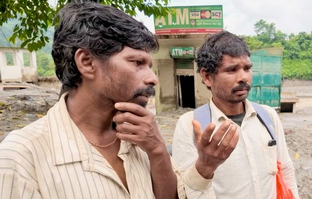 Talka Sada, right, and his brother, are searching for Sada's son, who has been missing since the August 25 floods that devastated large parts of northern Nepal [Smita Sharma/ Al Jazeera]