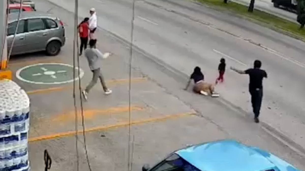 A woman slips and falls as a child runs into the street outside of a grocery store in Puebla, Mexico on Sept. 6, 2026.