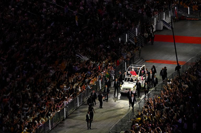 TOPSHOT - Pope Leo XIV greets worshippers from the Papamobile (popemobile) at the Stade de France stadium, in Saint-Denis on the outskirts of Paris on September 25, 2026 as he arrives to lead a prayer vigil with young people, as part of his four days visit to France.