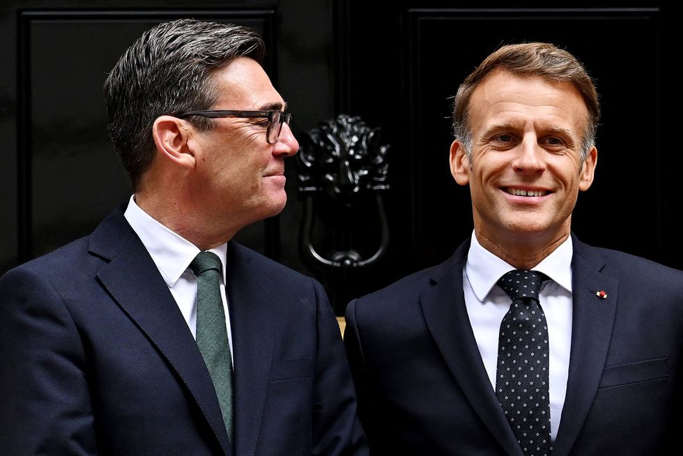 Andy Burnham looks at French President Emmanuel Macron