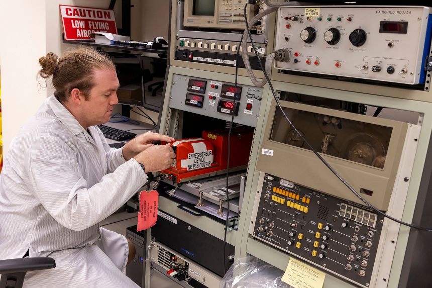 An NTSB investigator examines the flight data recorder from an Amazon cargo jet that barreled off a runway at Miami International Airport on Sunday. (NTSB via AP)
