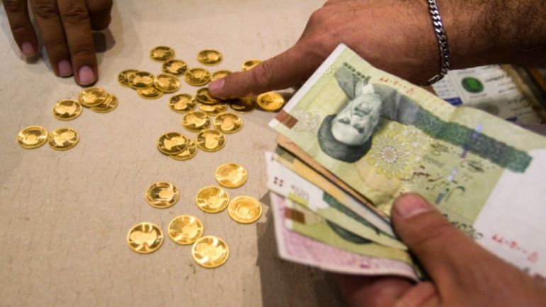 A customer buys Iranian gold coins at a currency exchange office in Tehran’s business district