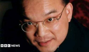 Close up image of Kenneth Law's face. He is looking at the camera and is wearing glasses.