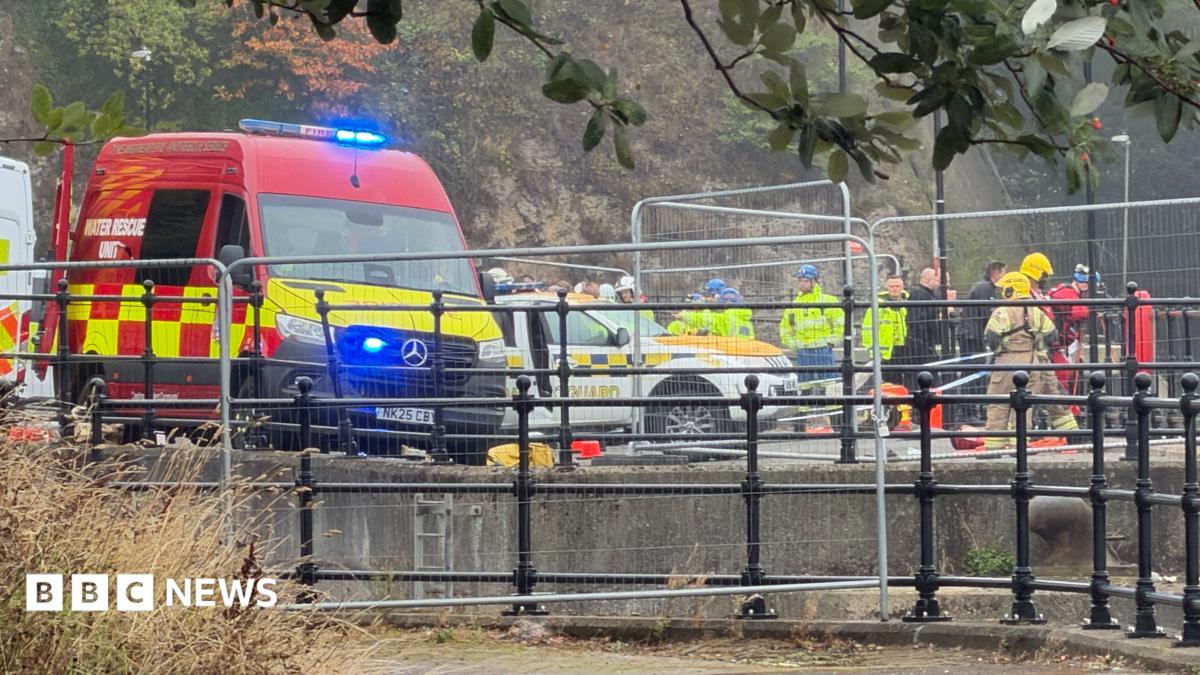 At least a dozen emergency service workers on the river bank in Sunderland, with a water rescue unit van in the foreground. There is temporary fencing around the area. Many of the emergency staff are wearing yellow high-viz jackets and helmets.