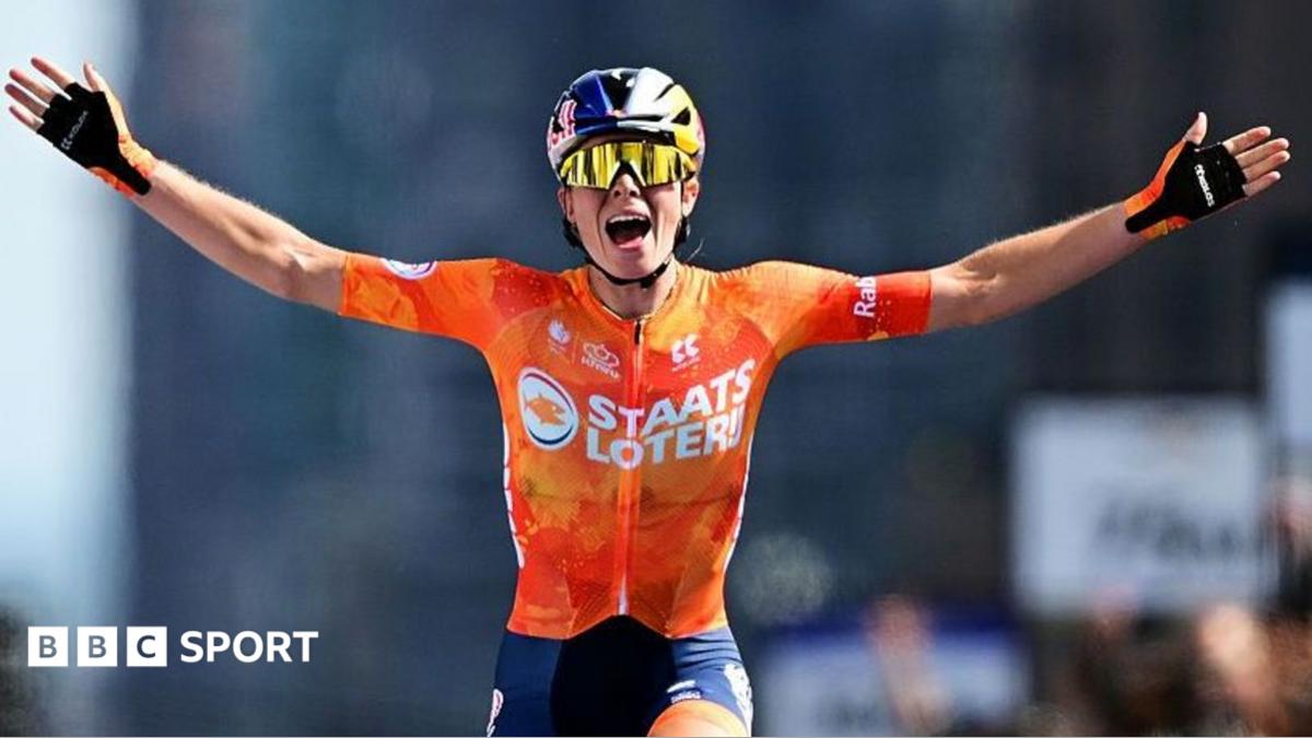 Demi Vollering has her hands outstretched after crossing the finish line