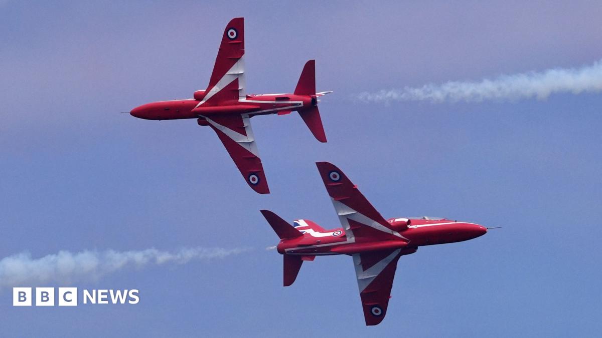 Two Red Arrows jets passing within feet of each other, flying in opposite directions