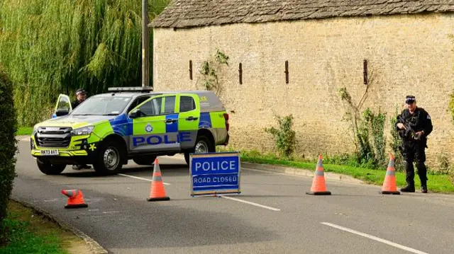 A police car and several cones outside a small building