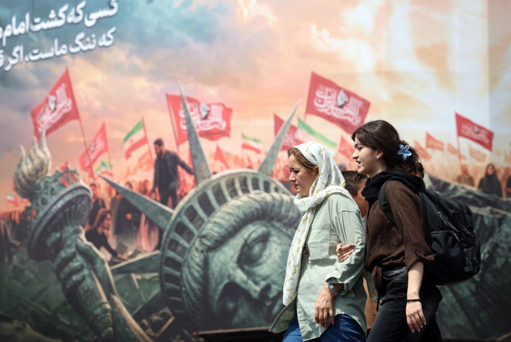 Two Iranian women walk past an anti-US billboard in Tehran.
