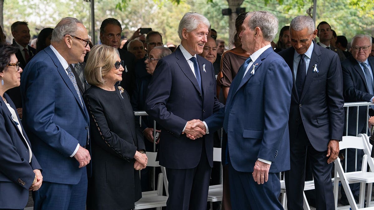 Bill Clinton greets George W. Bush and Barack Obama at a memorial ceremony in New York City.