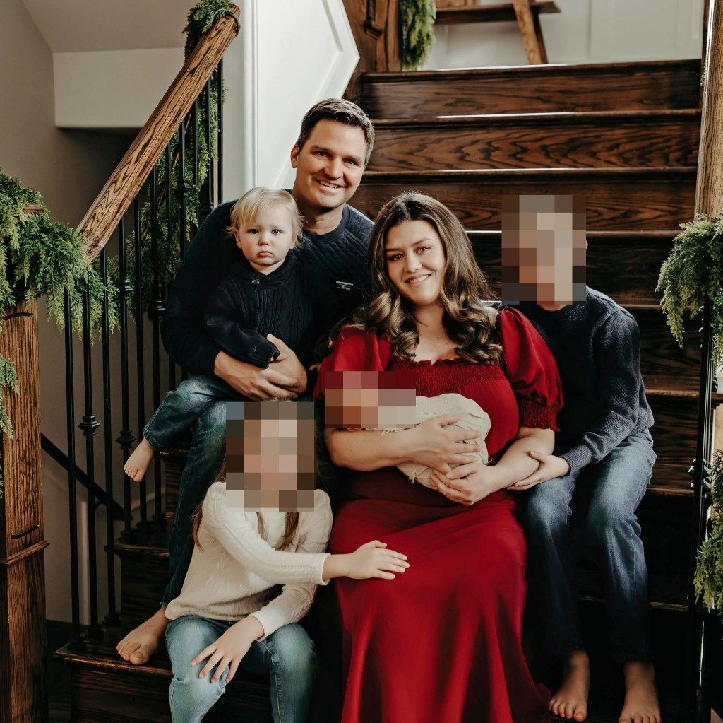 Corie Walsh and her family smile while sitting on wooden stairs decorated with garland.