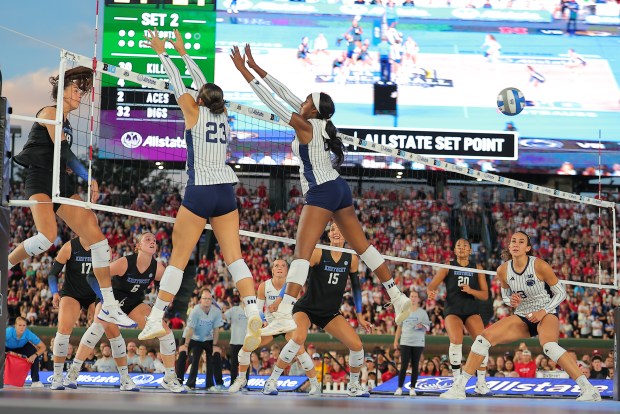 Kentucky's Morgan Gaerte, left, spikes the ball past Penn State's Haley Burgdorf and Gabrielle Nichols during a match in the Big Ten/SEC Volleyball Challenge Week on Sunday, Sept. 6, 2026, at Wrigley Field. (AP Photo/Melissa Tamez)