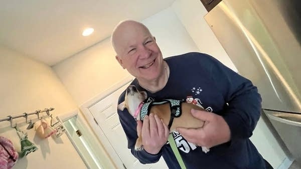 A man holds a puppy