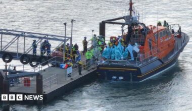 People wrapped in blankets on the back of an RNLI lifeboat moored by a pontoon at Eastney, Portsmouth, on 6.9.26