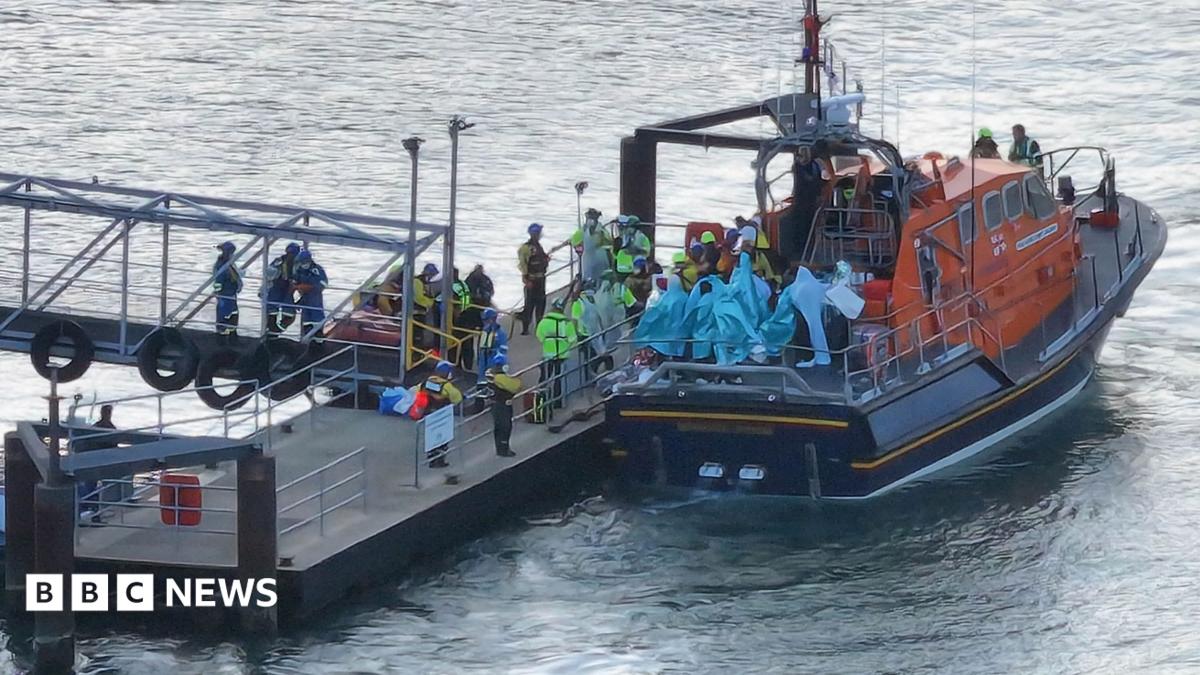 People wrapped in blankets on the back of an RNLI lifeboat moored by a pontoon at Eastney, Portsmouth, on 6.9.26