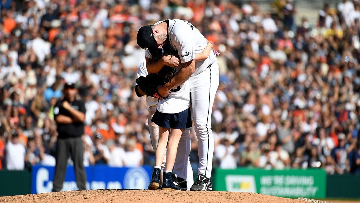 Genevieve Verlander hugs her father, Detroit Tigers pitcher Justin Verlander, during a baseball game.