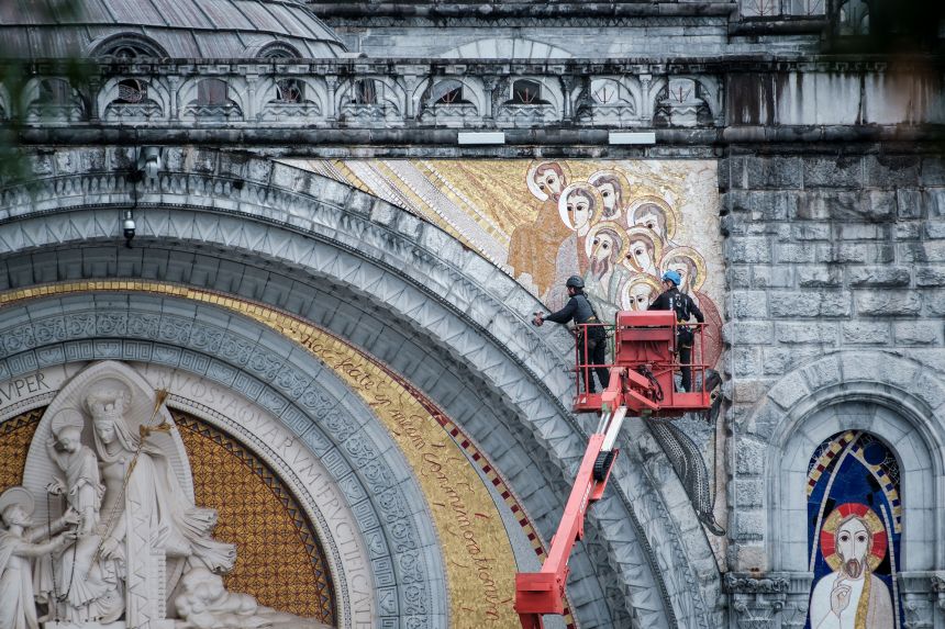 Workers are fitting the fixings that will hold in place the tarpaulins covering allegedly abusive priest Marko Rupnik's mosaics on the façade of the Basilica of the Rosary ahead of Pope Leo XIV s visit to the shrine at Lourdes.