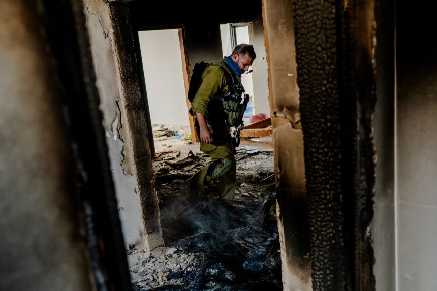 An Israeli soldier inspects the burnt interior of a house following the settler attack on the Tubasi family as they returned to the home they had been forced from. (Photo by Erik Marmor/Getty Images)