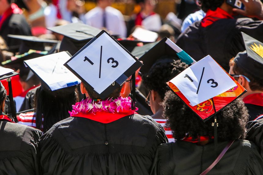 Stanford students wear a 1/3 sign on their caps to show solidarity for a Stanford rape victim during graduation ceremonies at Stanford University, in Palo Alto, California, on June 12, 2016.
