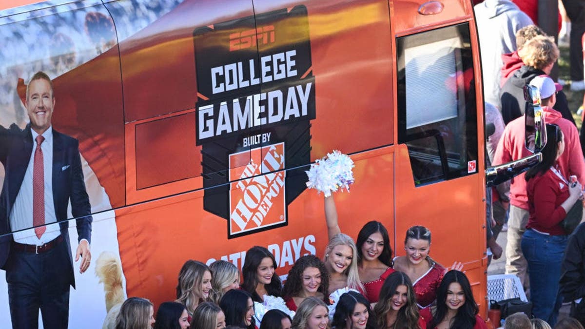 Indiana dance team members pose with the ESPN College GameDay bus.