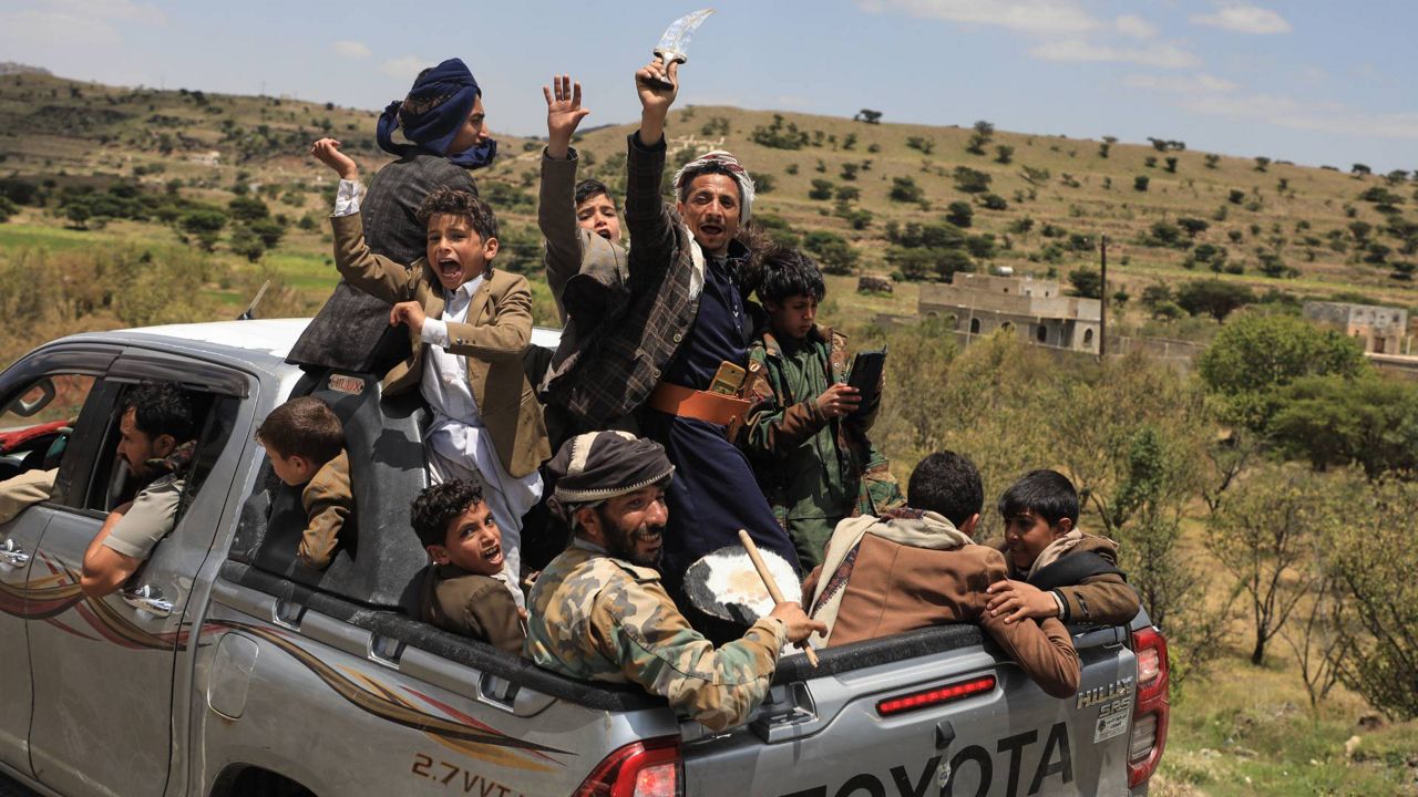 Yemeni civilians celebrate while riding in the back of a pickup truck in the Bani Matar district, Yemen, Saturday, Sept. 12, 2026, as they follow a convoy carrying Houthi prisoners freed in Mokha on its way to Sanaa following the Houthi takeover of the southern Red Sea port city. (AP Photo/STR)