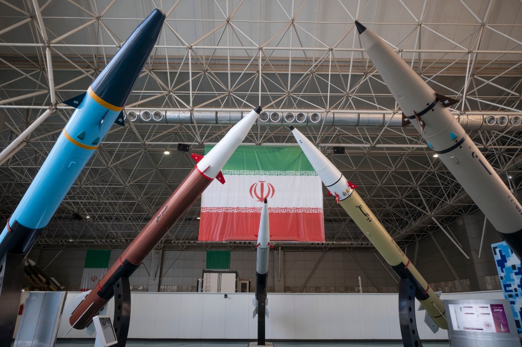 Iranian surface-to-surface missiles displayed in front of an Iran flag.