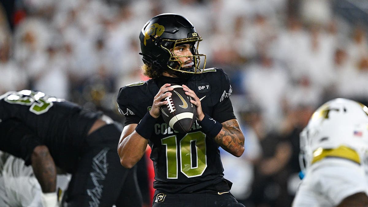 Julian Lewis #10 of Colorado drops back to pass during a college football game.