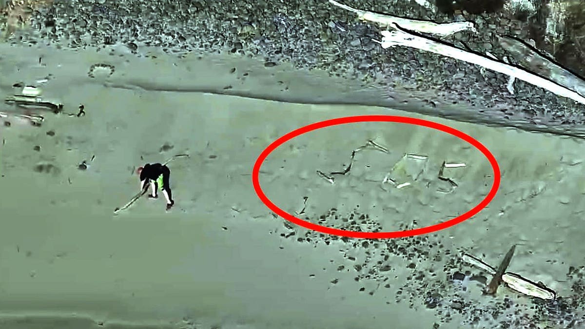 SOS made with sticks on Lost Boy Beach