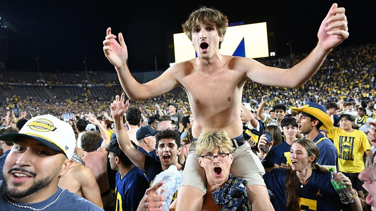 Michigan fans storm the field after a Hail Mary touchdown pass at Michigan Stadium.