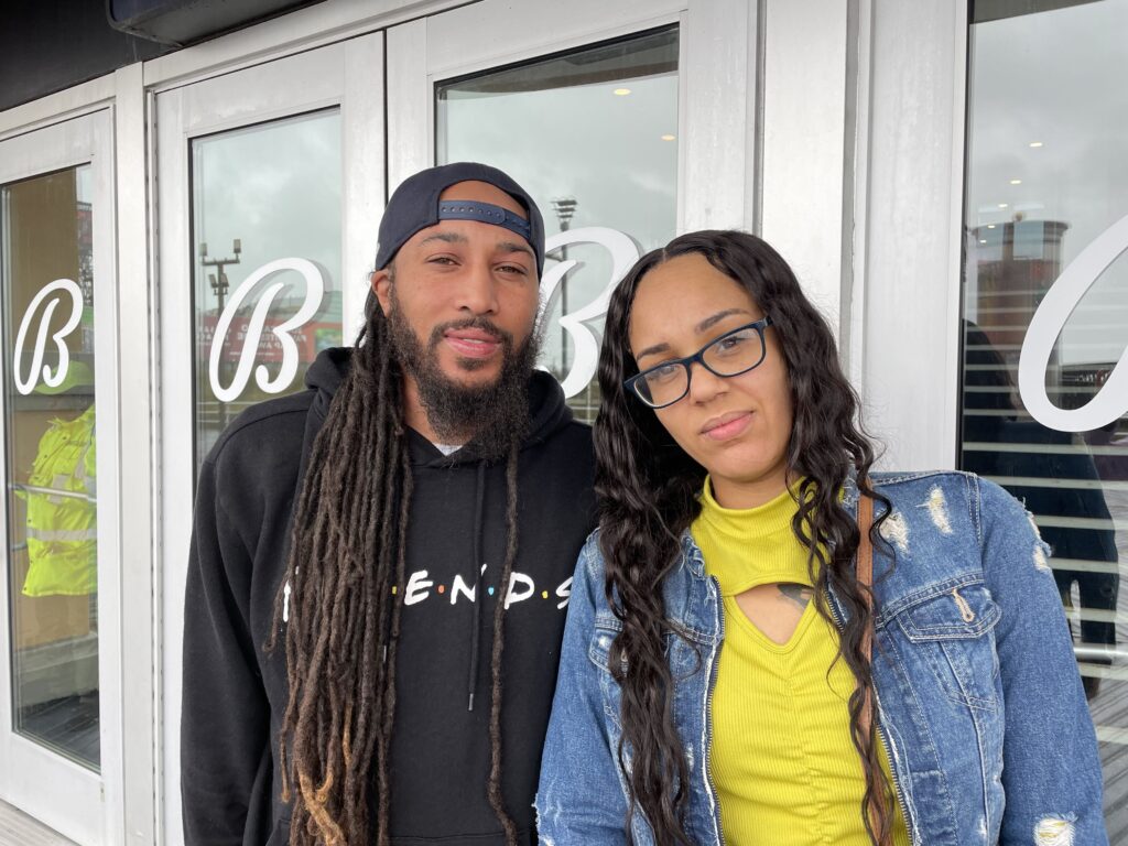 Frank Wainwright and Marangely Ritzo pose for a picture in front of a building