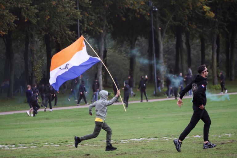 A child runs with the Prince's Flag with the symbol of the Dutch East India Company during a far-right demonstration in The Hague, Netherlands, September 19, 2026. REUTERS/Nicolas Economou